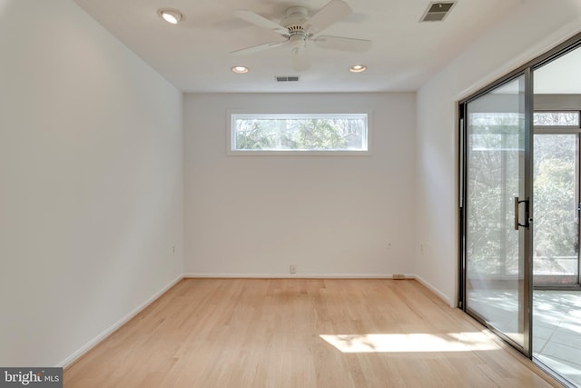 empty room featuring light wood-type flooring, visible vents, baseboards, and recessed lighting