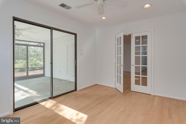 unfurnished room with baseboards, visible vents, wood finished floors, french doors, and recessed lighting