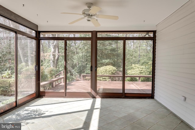 unfurnished sunroom featuring a ceiling fan