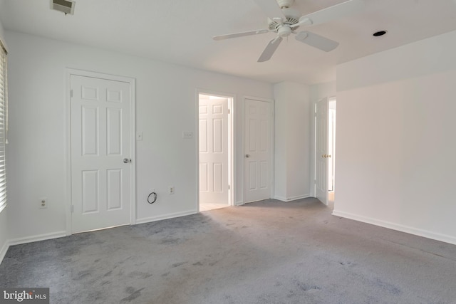 unfurnished bedroom with baseboards, visible vents, ceiling fan, and carpet flooring