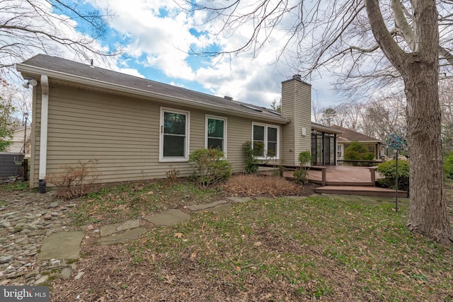 back of house featuring a chimney, a wooden deck, and central air condition unit