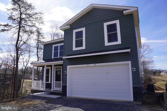 view of front facade featuring covered porch, an attached garage, a standing seam roof, and metal roof