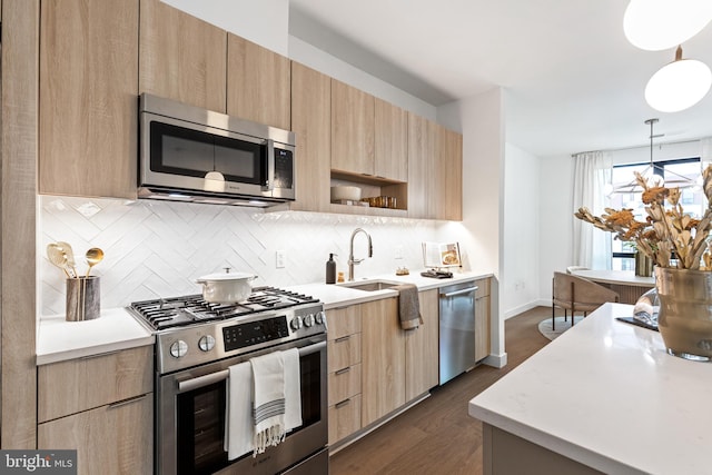 kitchen with modern cabinets, light brown cabinets, appliances with stainless steel finishes, and light countertops