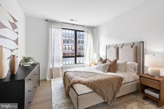 bedroom featuring light wood finished floors and visible vents