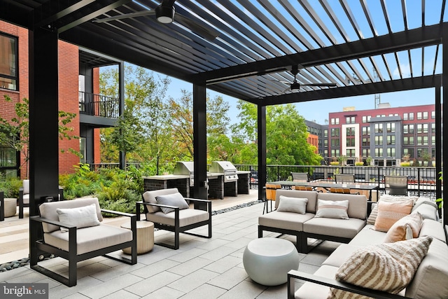 view of patio with exterior kitchen, an outdoor living space, area for grilling, and a pergola