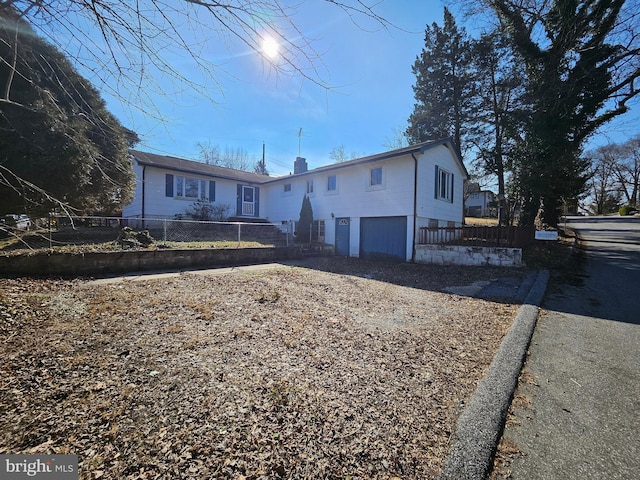 view of front of house featuring an attached garage and fence