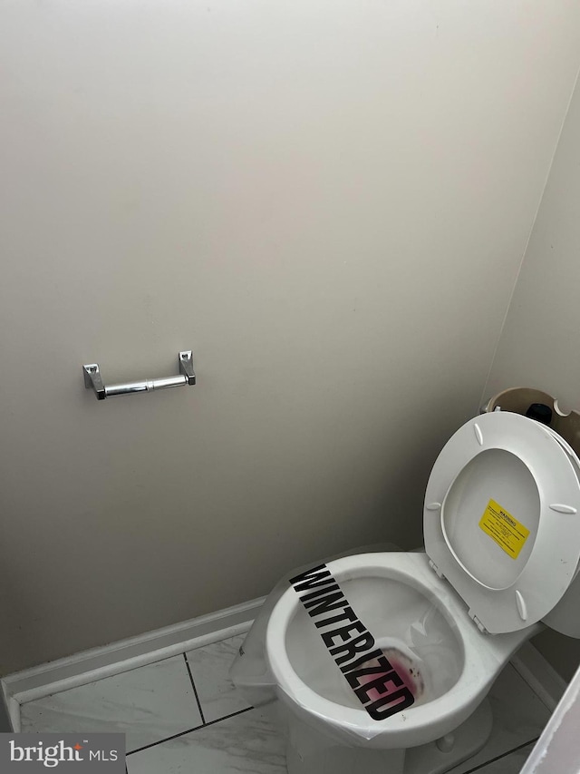 bathroom with marble finish floor and baseboards