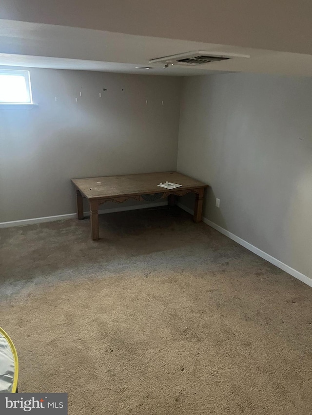 basement with carpet, visible vents, and baseboards