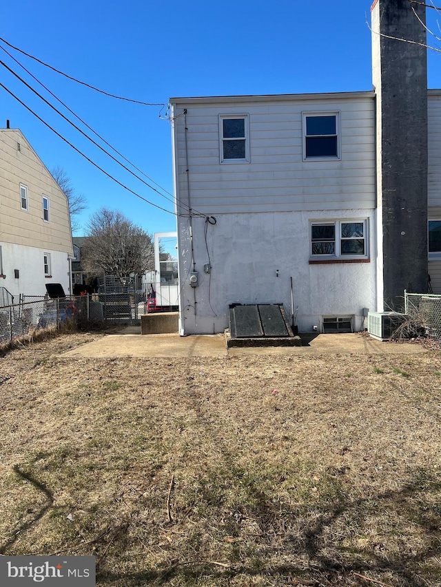 rear view of property featuring fence and stucco siding