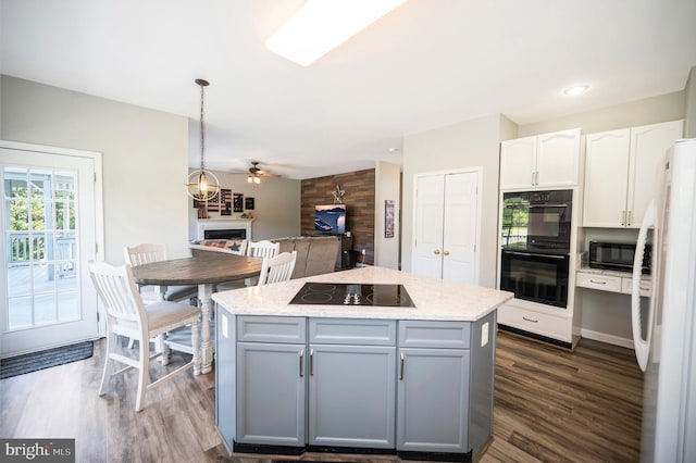 kitchen with dark wood-style floors, a kitchen island, gray cabinetry, black appliances, and white cabinetry