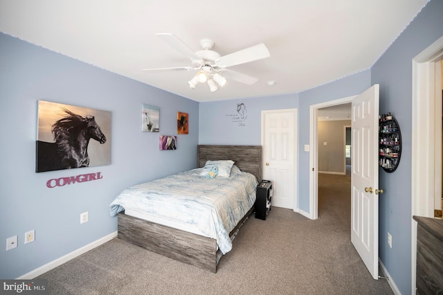 carpeted bedroom with ceiling fan and baseboards