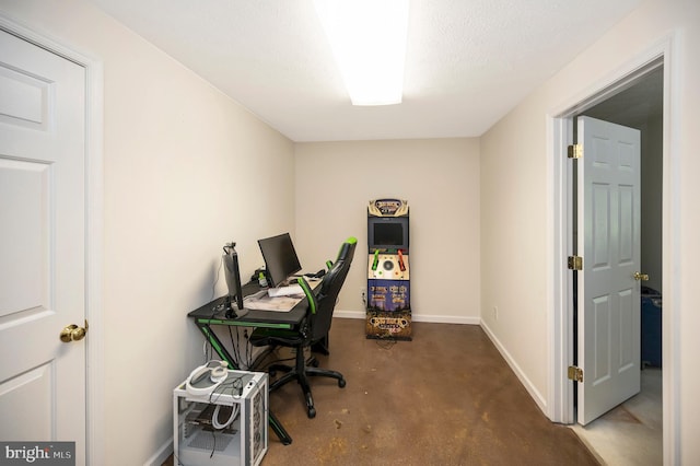 office space featuring concrete floors, a textured ceiling, and baseboards