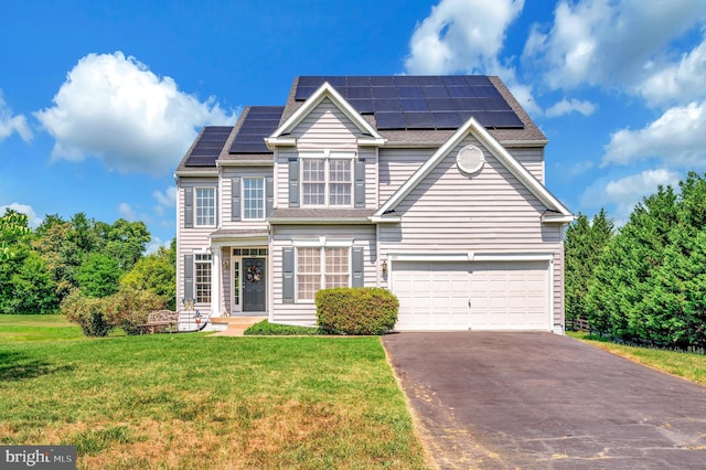 traditional-style house featuring a garage, aphalt driveway, solar panels, and a front yard