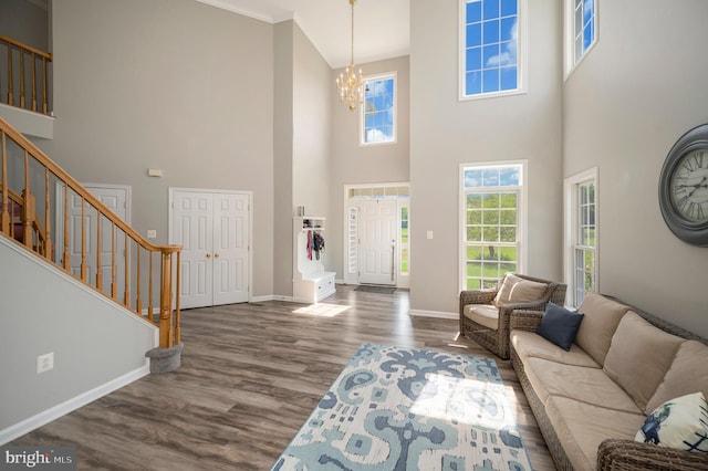 living room featuring a chandelier, stairway, wood finished floors, and baseboards