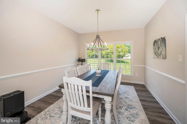 dining room with a notable chandelier, baseboards, and wood finished floors