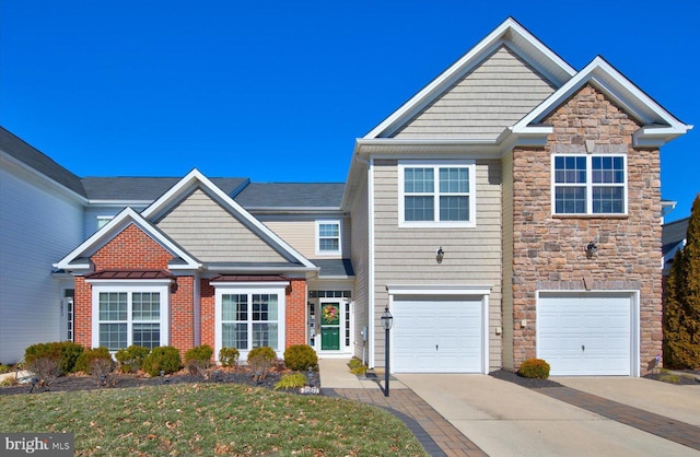 view of front of home with driveway, stone siding, and a garage