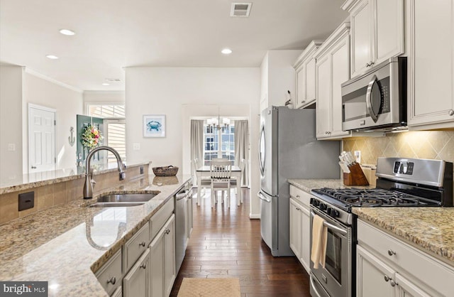 kitchen featuring dark wood-style flooring, visible vents, decorative backsplash, appliances with stainless steel finishes, and a sink