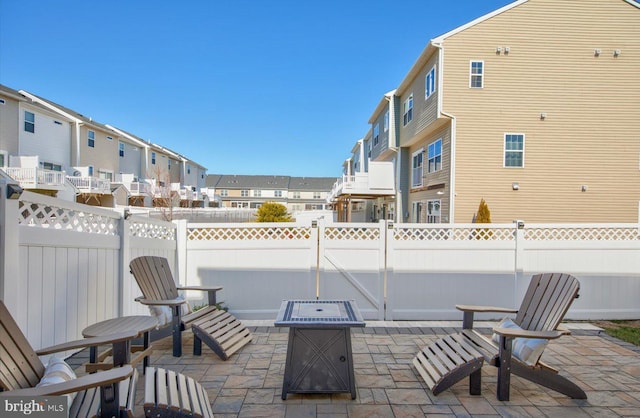 view of patio featuring a fenced backyard, a residential view, and a fire pit