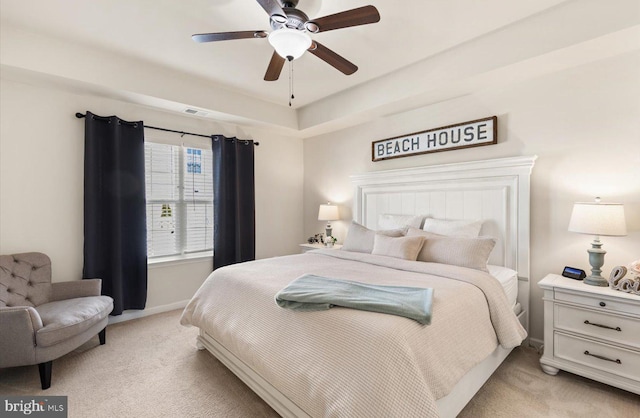 bedroom with light carpet, ceiling fan, visible vents, and baseboards