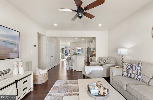 living area featuring dark wood-type flooring, recessed lighting, visible vents, and a ceiling fan