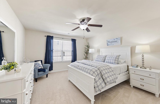 bedroom featuring baseboards, a ceiling fan, and light colored carpet