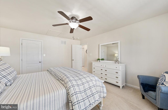 bedroom featuring light colored carpet, a ceiling fan, baseboards, visible vents, and attic access