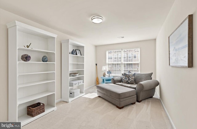 living area featuring baseboards and carpet flooring