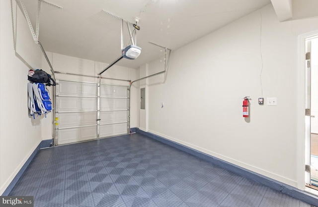 garage with a garage door opener and baseboards