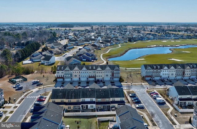 drone / aerial view with view of golf course, a water view, and a residential view