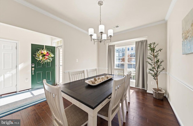 dining space featuring a notable chandelier, dark wood-type flooring, baseboards, and crown molding