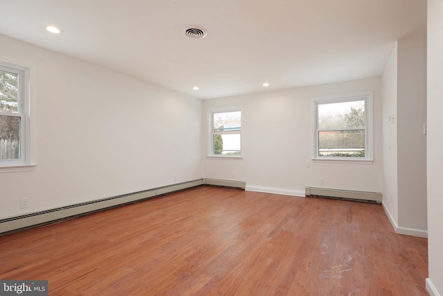 spare room featuring a baseboard radiator, recessed lighting, visible vents, baseboard heating, and light wood finished floors