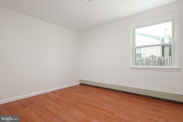 spare room with light wood-style floors, baseboards, and baseboard heating