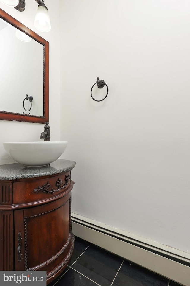 bathroom with a baseboard heating unit, tile patterned flooring, and vanity