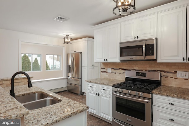 kitchen featuring appliances with stainless steel finishes, visible vents, a sink, and a notable chandelier