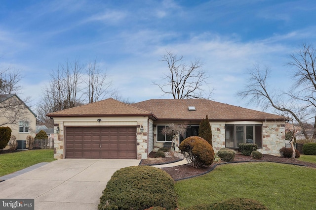 ranch-style home featuring driveway, stone siding, an attached garage, and a front lawn