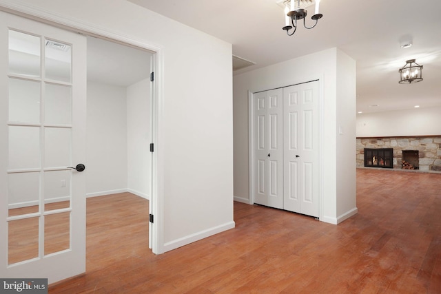 corridor with baseboards and wood finished floors