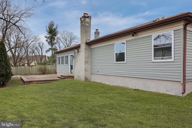 back of property with a patio area, fence, a chimney, and a lawn