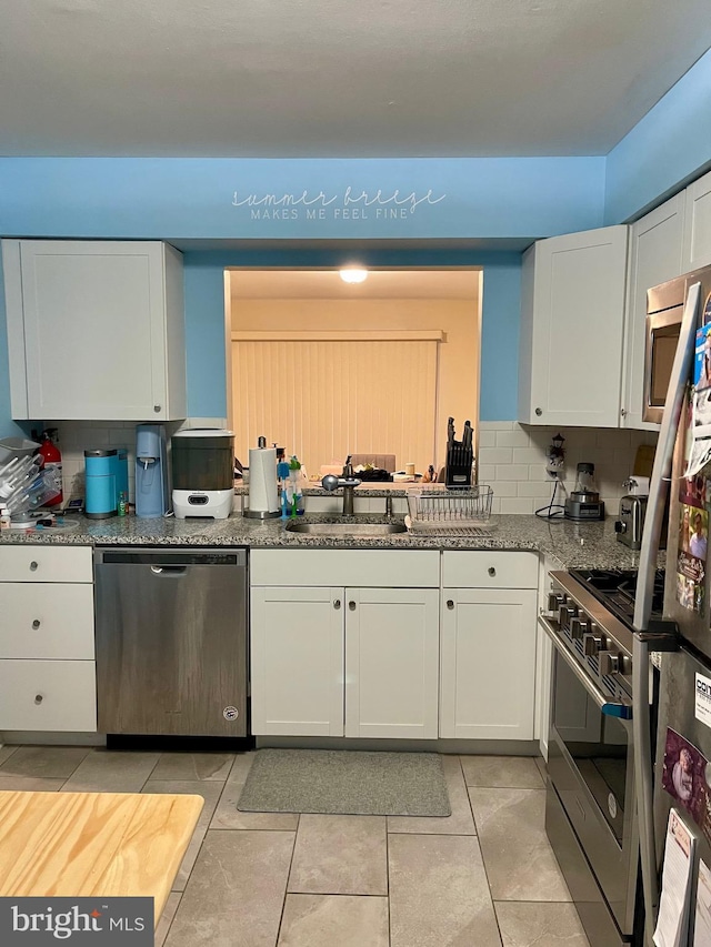 kitchen featuring white cabinetry, appliances with stainless steel finishes, and backsplash