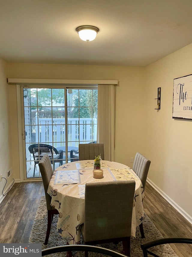 dining area featuring dark wood-style flooring and baseboards