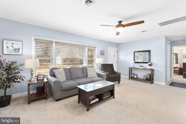 living area with visible vents, baseboards, attic access, and light colored carpet