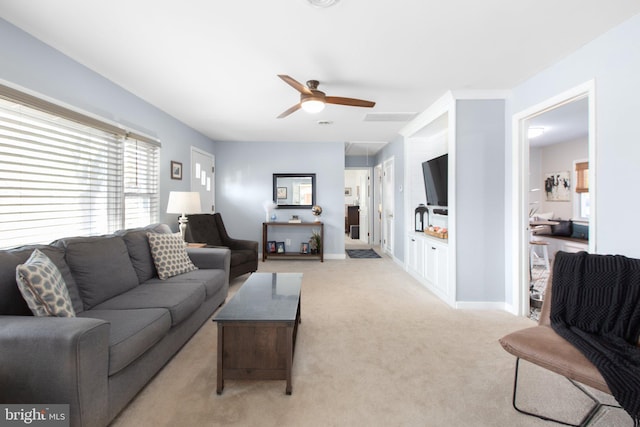 living room featuring a ceiling fan, light carpet, and baseboards