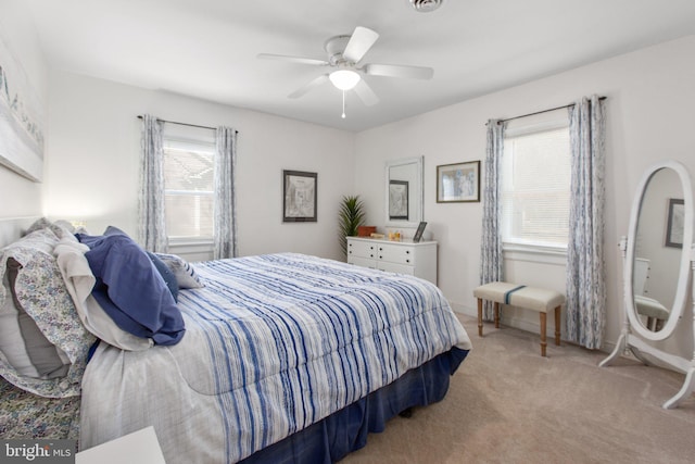 carpeted bedroom with visible vents, ceiling fan, and baseboards