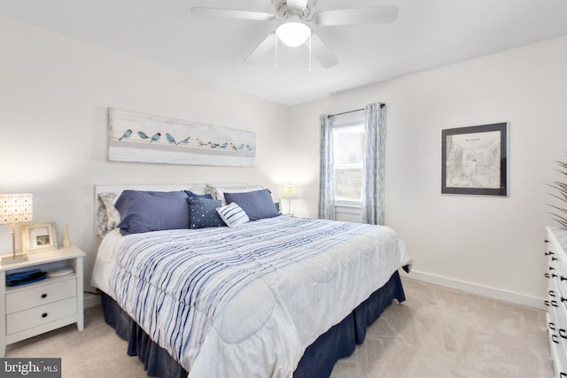 bedroom featuring light carpet, ceiling fan, and baseboards