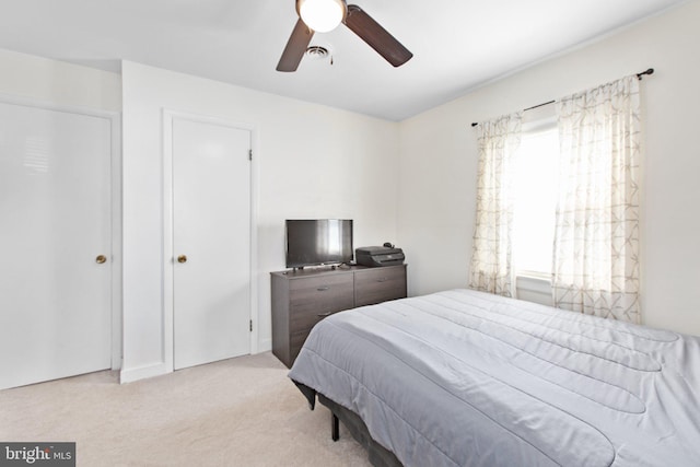 carpeted bedroom with ceiling fan and visible vents