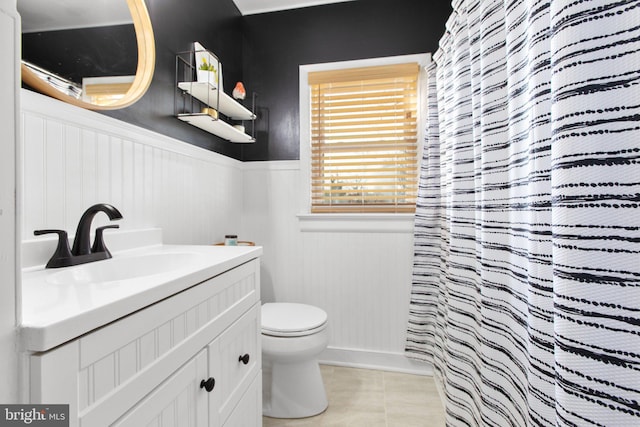 full bathroom featuring wainscoting, toilet, a shower with curtain, tile patterned floors, and vanity