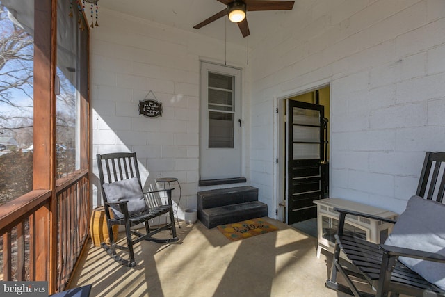 exterior space featuring ceiling fan and concrete block siding