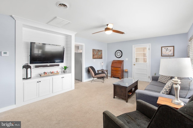 living room featuring baseboards, a ceiling fan, visible vents, and light colored carpet