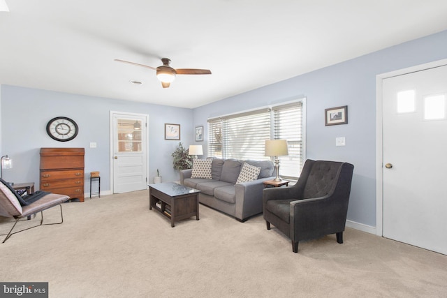 living room featuring a healthy amount of sunlight, ceiling fan, baseboards, and light colored carpet