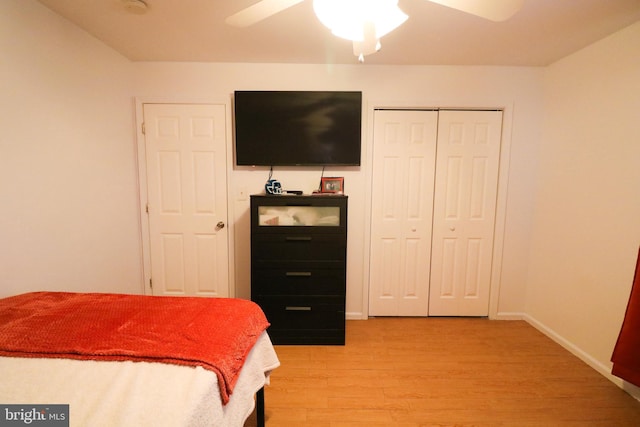 bedroom with ceiling fan, a closet, light wood-type flooring, and baseboards