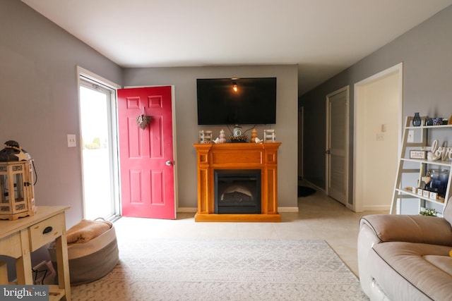 living area featuring a fireplace with raised hearth and light tile patterned flooring